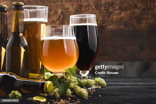 glasses of beer with green hops and wheat - beer bottles stock pictures, royalty-free photos & images