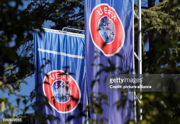 September 2018, Switzerland, Nyon: Flags with the UEFA logo waft in the garden of the headquarters of the Union of European Football Associations on...
