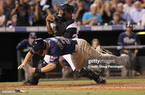 Aaron Cunningham of the San Diego Padres is tagged out at home by catcher Miguel Olivo of the Colorado Rockies for the final out of the third inning...
