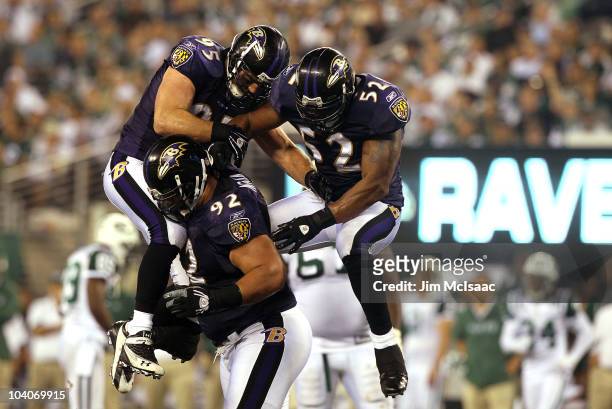 Ray Lewis and Jarret Johnson jump on Haloti Ngata of the Baltimore Ravens after a sack in the fourth quarter against the New York Jets during their...