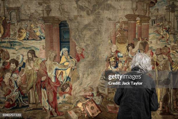 Visitor views a 16th Century tapestry depicting St Paul burning heathen books in the premises of London tapestry expert and art dealer Simon Franses...