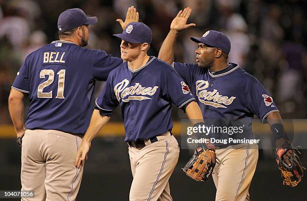 Heath Bell, Aaron Cunningham and Miguel Tejada of the San Diego Padres celebrates the Padres 6-4 victory over the Colorado Rockies at Coors Field on...