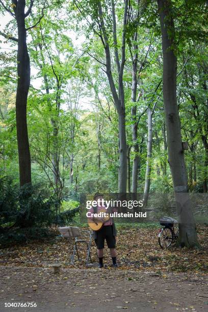 Germany Deutschland Berlin Ein Mann in Lederhosen singt im Tiergarten zur Gitarre..