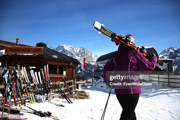 Female skier walks with her skis on her shoulder to the ski hut restaurant Brettlalm on March 19, 2010 in Lermoos, Tyrol, Austria.