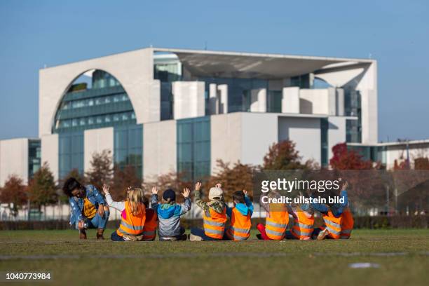 Germany Deutschland Berlin Kindergartenkinder heben zum Gruppenfoto vor dem Bundeskanzleramt die Hände.