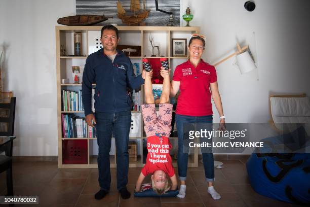 French skipper Romain Attanasio and English skipper Samantha Davies, husband and wife, pose with their son in their house in Tregunc, western France,...