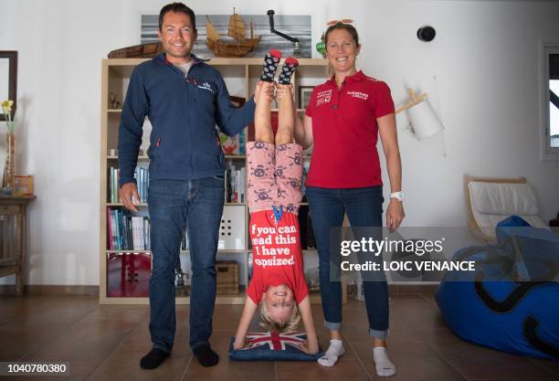 French skipper Romain Attanasio and English skipper Samantha Davies, husband and wife, pose with their son in their house in Tregunc, western France,...