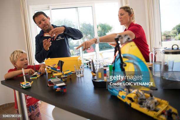 French skipper Romain Attanasio and English skipper Samantha Davies, husband and wife, play lego with their son in their house in Tregunc, western...
