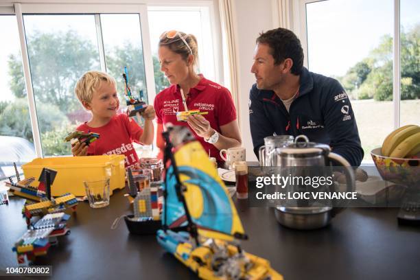 French skipper Romain Attanasio and English skipper Samantha Davies, husband and wife, play lego as they take a snack with their son in their house...