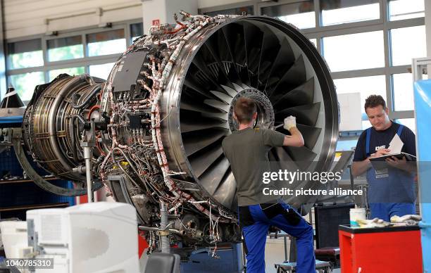 Two technicians work on an aero engine in a maintenance hangar of the MTU Maintenance in Hanover, Germany, 11 July 2013. Photo: NICO POINTNER | usage...