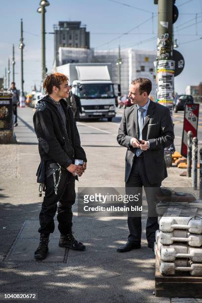 Deutschland Germany Berlin Ein bettelnder Punk lacht einen Mann im Anzug an, der ihm gerade Geld in seinen Becher geworfen hat. Szene an der...