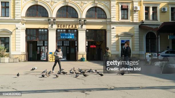 Junge füttert Tauben im Alten Hauptbahnhof in Belgrad