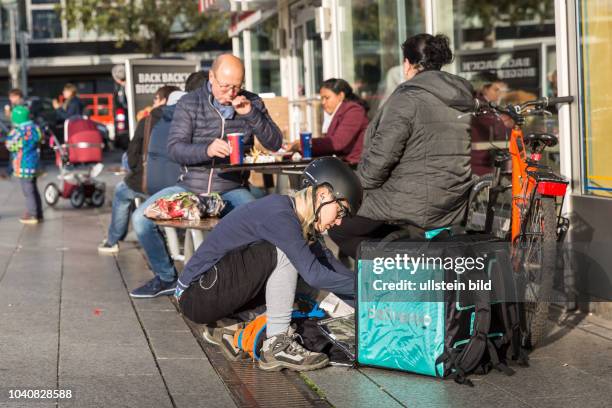 Germany Deutschland Berlin Ein Fahrradkurier packt seinen TransportbehÃ¤lter mit Bestellung von einem Fastfood-Restaurant vor dem Europazentrum.