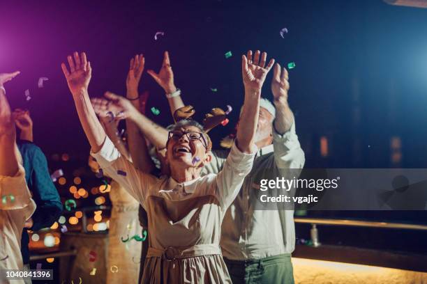 senior new year rooftop party - 70 year male stock pictures, royalty-free photos & images