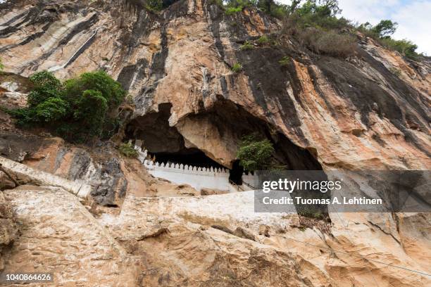 limestone cliff and entrance to the famous pak ou caves near luang prabang in laos, viewed from the front. - roccia carsica foto e immagini stock