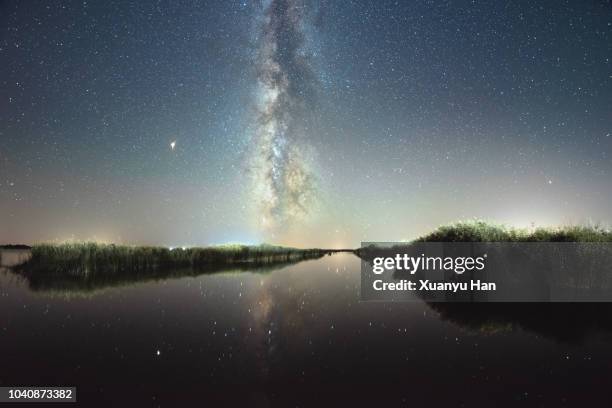 night sky lake and milky way galaxy - rivier gras oever stockfoto's en -beelden