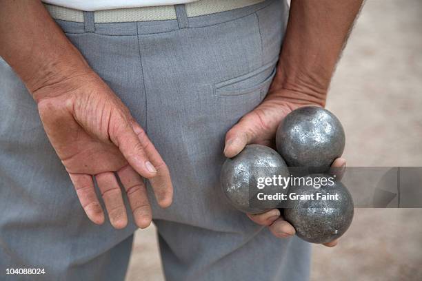 older man holding balls boules for game. - boules stock-fotos und bilder