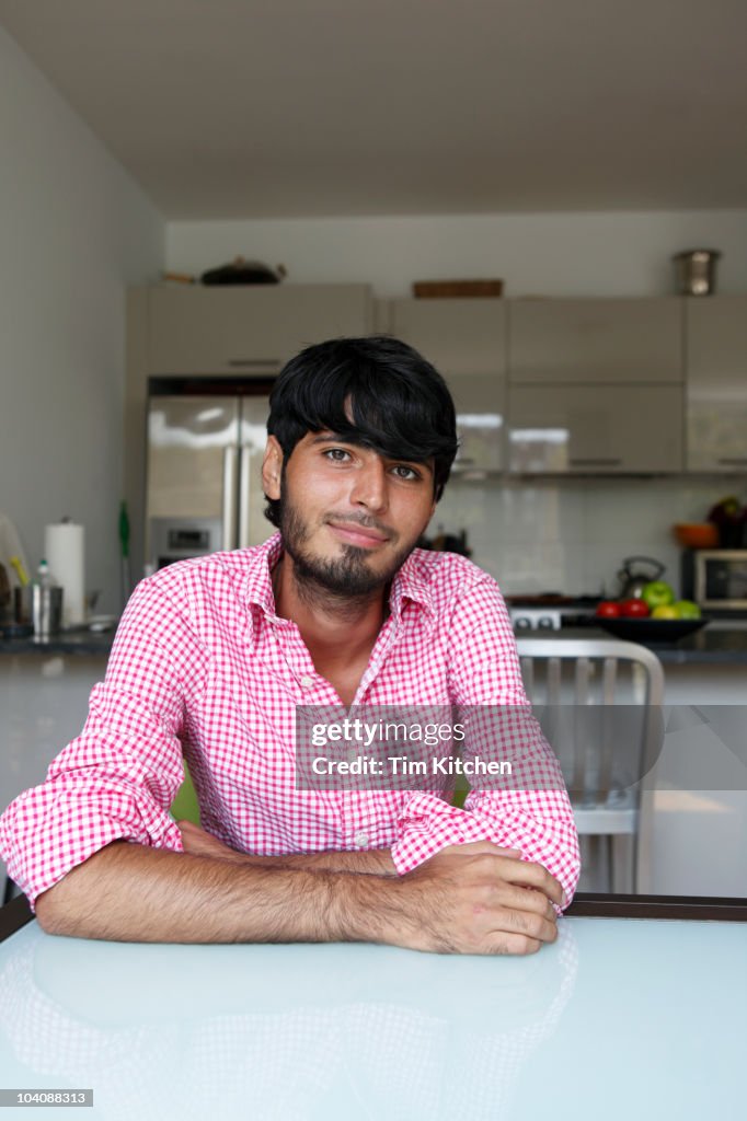 Man at kitchen table, smiling, portrait