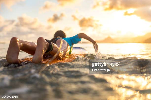 young girl surfing at sunset - indonesia surfing imagens e fotografias de stock