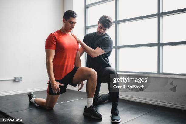 ejercicio de rango de movimiento - personal trainer fotografías e imágenes de stock