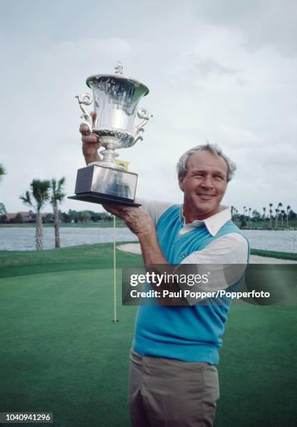 American professional golfer Arnold Palmer lifts the trophy in the air after winning the Senior PGA Championship at the PGA National Golf Club in...