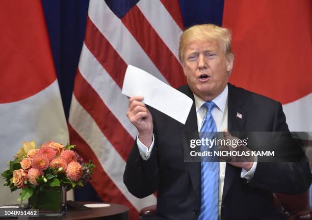 President Donald Trump shows a letter he said he received the previous day from North Korean leader Kim Jong Un, during a bilateral meeting with...