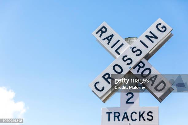 railroad crossing sign against clear blue sky. seattle, washington, usa. - level crossing stock pictures, royalty-free photos & images