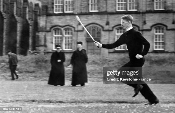 Révérend Martin Carroll participant à une course à pied, tient dans ses mains un relais, en France, en juin 1965.