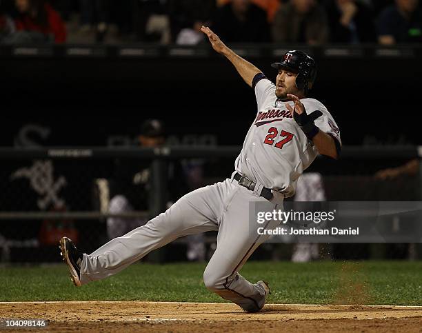 Hardy of the Minnesota Twins slides into the plate to score a run against the Chicago White Sox at U.S. Cellular Field on September 14, 2010 in...