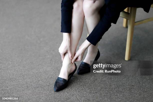 businesswoman with ankle pain in office - legs on desk bildbanksfoton och bilder