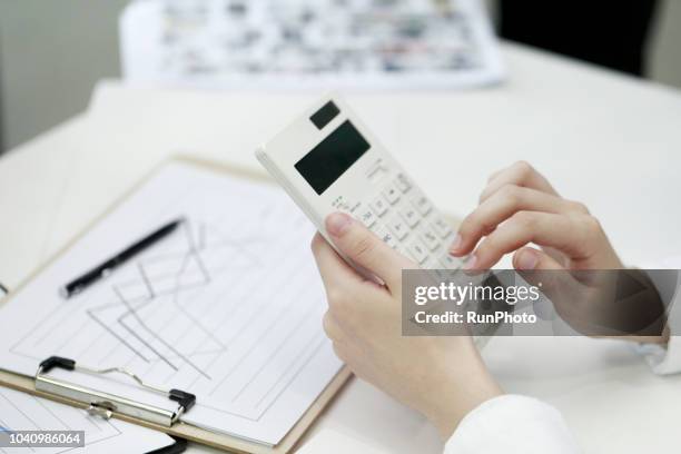 businesswoman using calculator in office - rechenmaschine stock-fotos und bilder