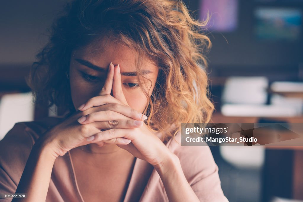 Cansado de joven que se inclina la cabeza en las manos