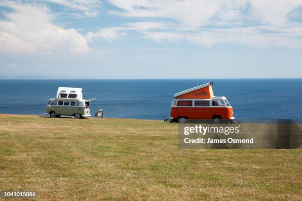 classic vw camper vans at coastal campsite - volkswagen stock pictures, royalty-free photos & images