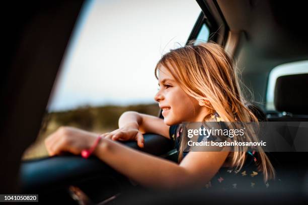 meisje kijkt uit raam van de auto - car window stockfoto's en -beelden