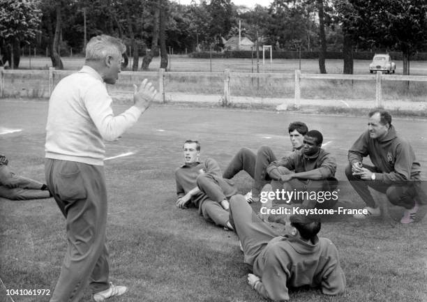 Entraîneur Joseph Maigrot entraîne les athlètes français dont Roger Bambuck avant les JO de Tokyo le 21 août 1964 à Fontainebleau, France.