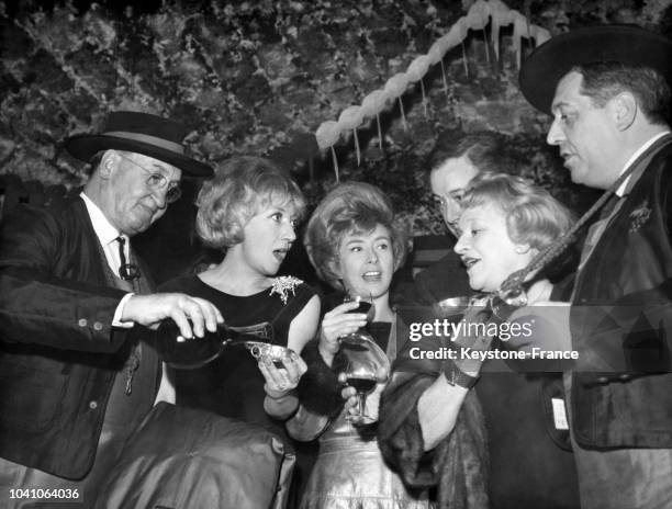 Les comédiens Colette Brosset, Robert Dhéry et Jane Sourza dégustent le Beaujolais nouveau dans les caves de la Tour Eiffel, circa 1960 à Paris,...