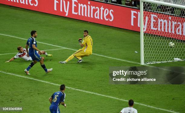 Mario Goetze of Germany scores 1-0 goal against goalkeeper Sergio Romero of Argentina during the FIFA World Cup 2014 final soccer match between...