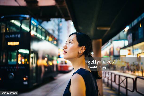 Young Asian woman traveller visiting and exploring busy city street in downtown Hong Kong