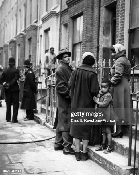 Des habitants d'origine africaine observent la maison dans laquelle un incendie s'est déclaré, tuant trois enfants, dans le quartier d'Holloway le 17...