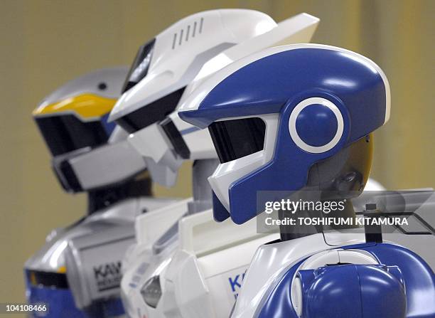 The HRP-4, a "slim athlete" robot is displayed beside its previous models, the HRP-2 and the HRP-3 during a joint press preview by Kawada Industries...