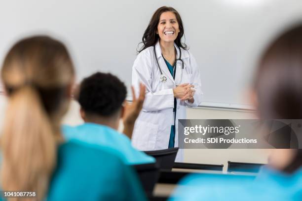 female medical professor laughs at student's joke - health seminar stock pictures, royalty-free photos & images