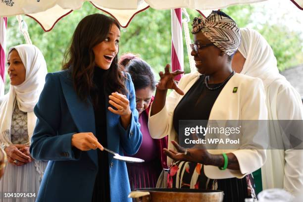 Meghan, Duchess of Sussex helps to prepare food at an event to mark the launch of a cookbook with recipes from a group of women affected by the...