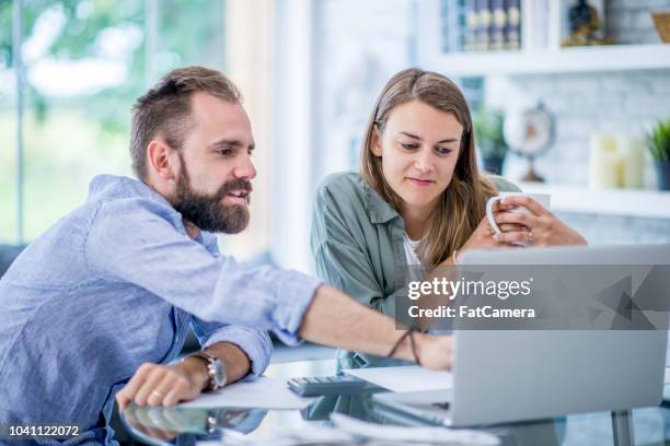looking over finances - mid adult couple stock pictures, royalty-free photos & images