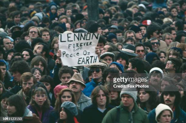 Fans mourn musician John Lennon, formerly of the Beatles, with a banner reading 'Lennon Forever - Peace on Earth', December 1980. Lennon was shot and...