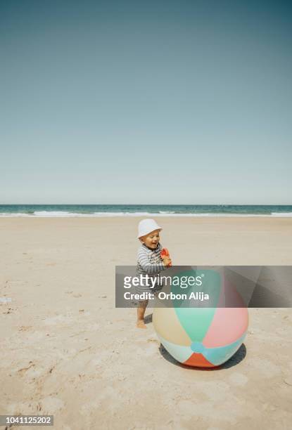 jongen spelen op het strand met de bal - baby sommer stockfoto's en -beelden
