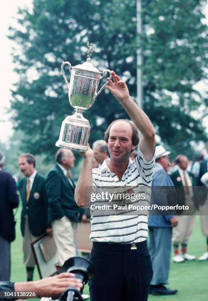 American professional golfer Larry Nelson raises up the Championship Trophy after finishing in first place to win the 1983 US Open golf tournament at...