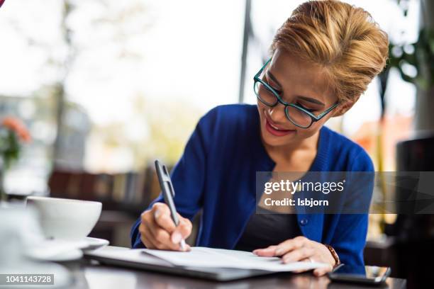 blondie asian female running small business. - order pad stock pictures, royalty-free photos & images