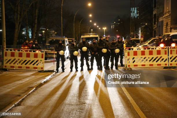 Policemen block a road towards the fair grounds during a demonstration of left-wing groups against the OSCE Ministerial Council Meeting in Hamburg,...