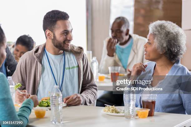 confident young man enjoys soup kitchen meal - homeless shelter man stock pictures, royalty-free photos & images