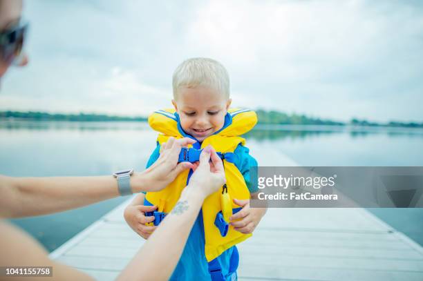 sohn mit schwimmweste hilft - safety stock-fotos und bilder